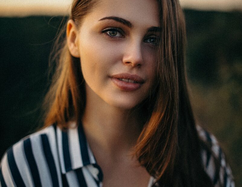smiling woman wearing white and black pinstriped collared top