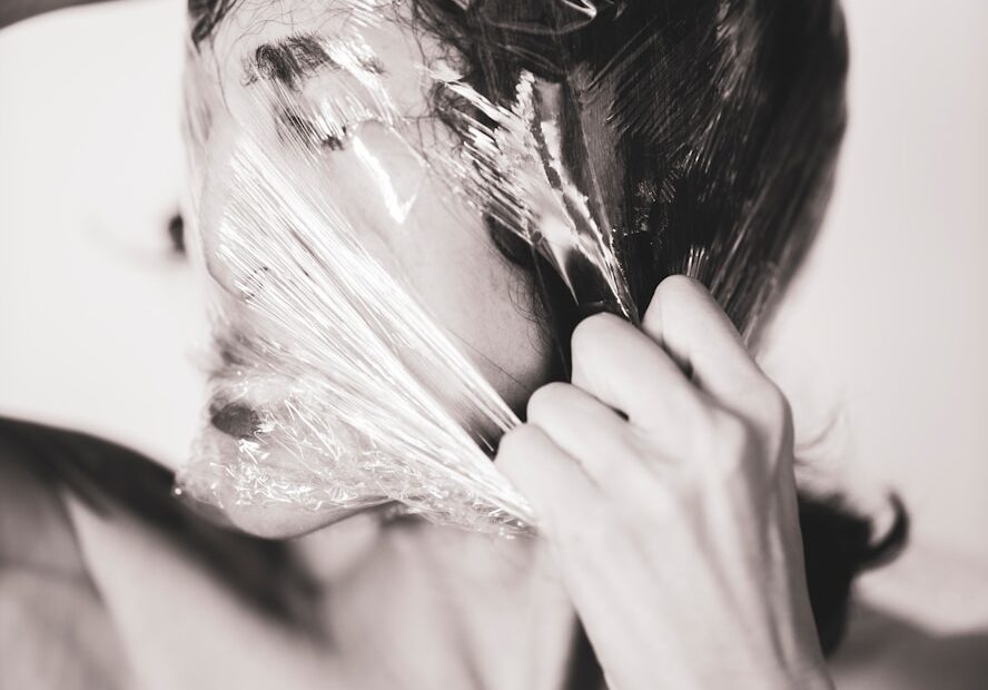 woman covering face with white textile